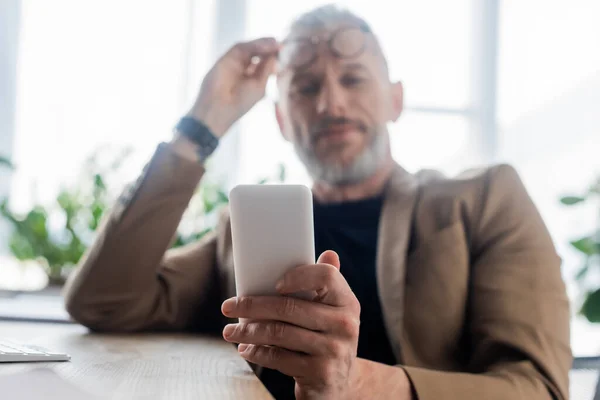 Selektivní Zaměření Podnikatele Držícího Smartphone Kanceláři — Stock fotografie