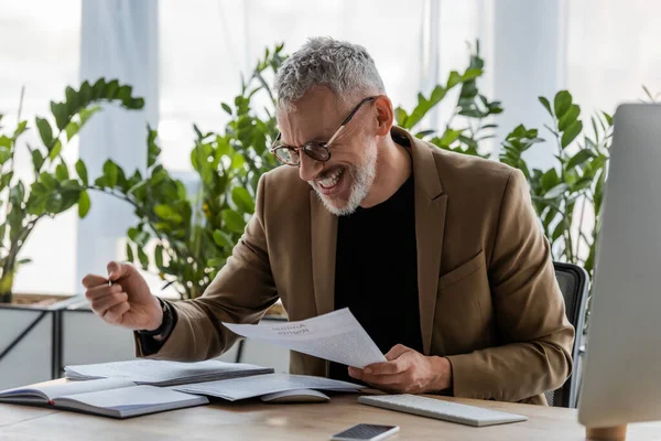 Alegre Hombre Negocios Mirando Documento Cerca Teléfono Inteligente Con Pantalla — Foto de Stock