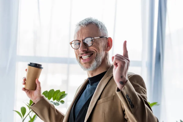 Hombre Negocios Feliz Gafas Sosteniendo Taza Papel Señalando Con Dedo —  Fotos de Stock