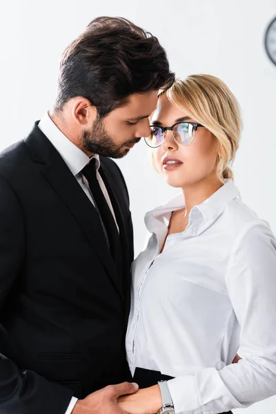 Business couple holding hands while flirting in office — Stock Photo