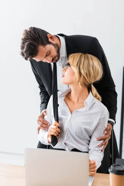 Sensual businesswoman flirting with colleague by workplace — Stock Photo