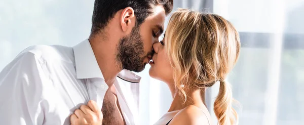 Casal de negócios beijando enquanto flertando no escritório, tiro panorâmico — Fotografia de Stock