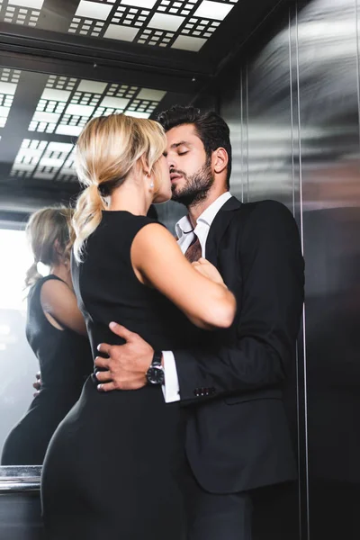 Couple d'affaires se déshabiller tout en embrassant dans l'ascenseur de bureau — Photo de stock