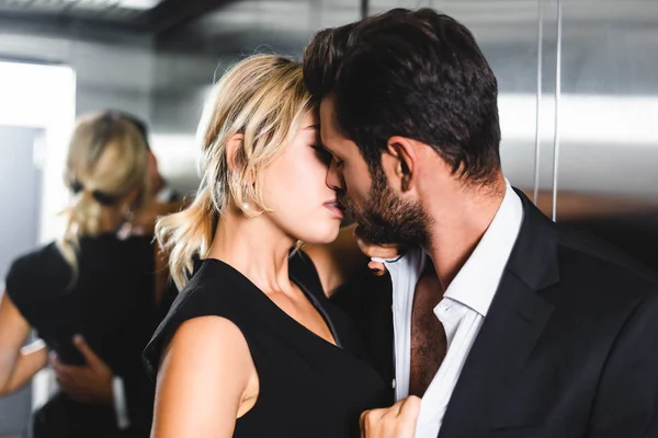 Femme d'affaires embrasser collègue dans l'ascenseur de bureau — Photo de stock