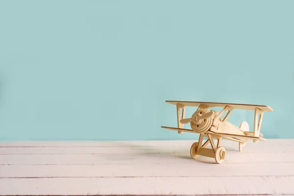 Dřevěná hračka letadlo proti zelené pozadí s copyspace — Stock fotografie