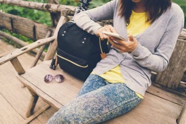 Ahşap Bank Smartphone kullanarak kadın Gezgin