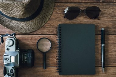Ahşap backgro üzerinde kamera boşaltmak ve retro siyah defter