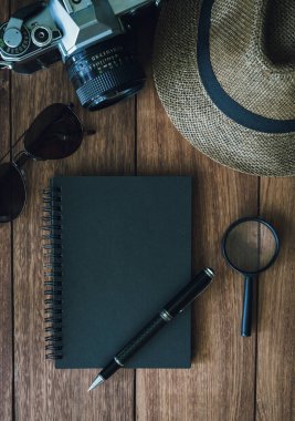 Ahşap backgro üzerinde kamera boşaltmak ve retro siyah defter