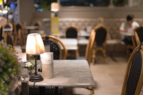 Lámpara de escritorio en la mesa en el restaurante por la noche — Foto de Stock