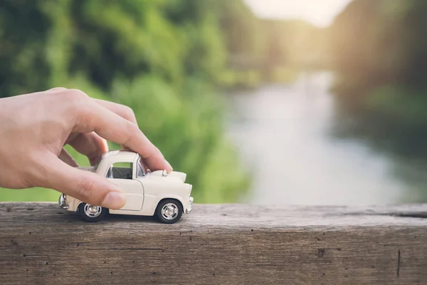 Ruka držící auto s krajinném zázemí — Stock fotografie