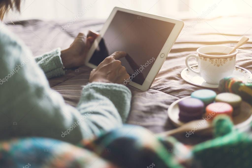 Young woman using tablet at cozy home atmosphere