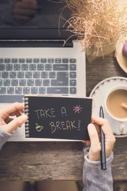 Ahşap masa üzerinde bir dizüstü bilgisayar kullanarak çalışan genç kadın