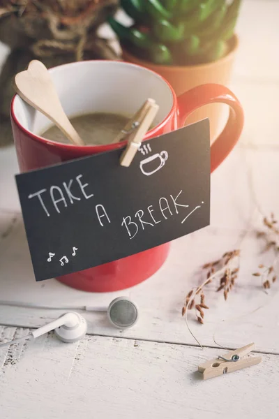 Taza roja de café con tomar una nota de descanso — Foto de Stock