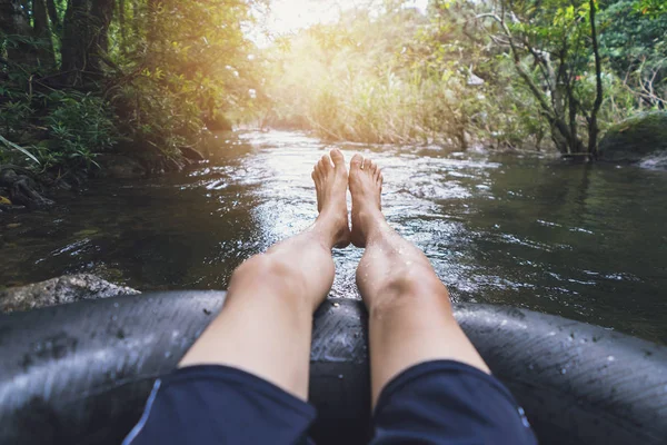 Hombre flotando por un canal en un tubo de explosión —  Fotos de Stock