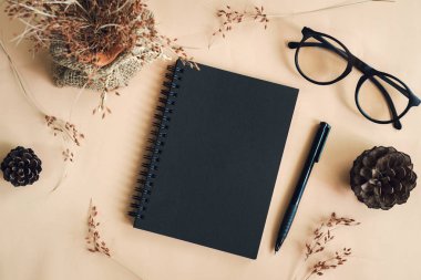 Çalışma alanındaki boş defter ile kuru çiçek