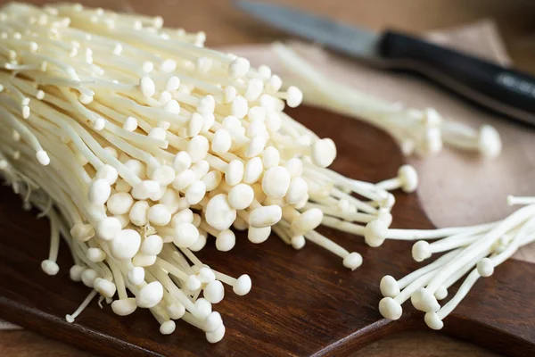 Eski ahşap masa üzerinde enoki mantar