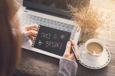 Ahşap masa üzerinde bir dizüstü bilgisayar kullanarak çalışan genç kadın