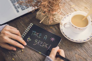 Ahşap masa üzerinde bir dizüstü bilgisayar kullanarak çalışan genç kadın