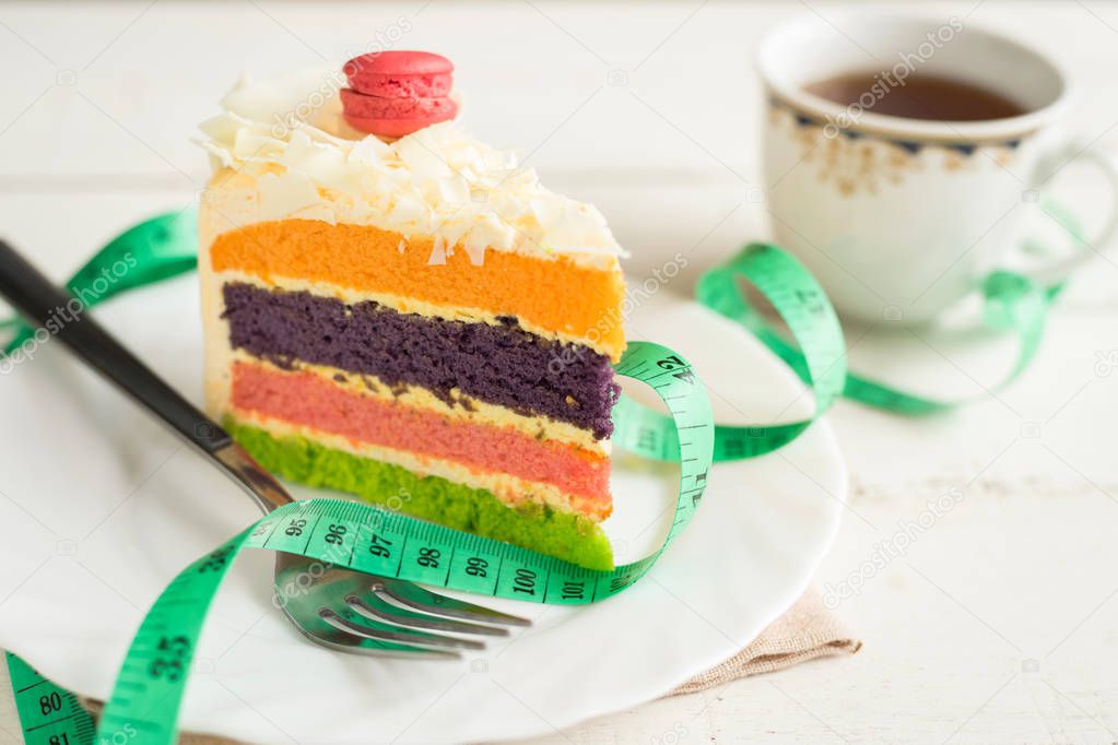 Fancy cake with measure tape and cup of tea