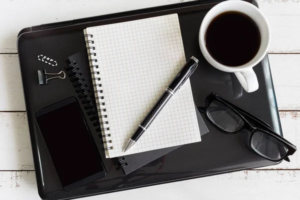 Cuaderno con portátil y taza de café en escritorio de madera — Foto de Stock