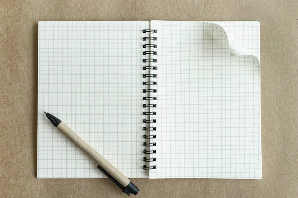 Cuaderno en blanco con pluma sobre fondo marrón —  Fotos de Stock