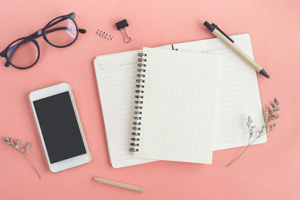 Blank notebook with cellphone on color background in workspace — Stock Photo, Image