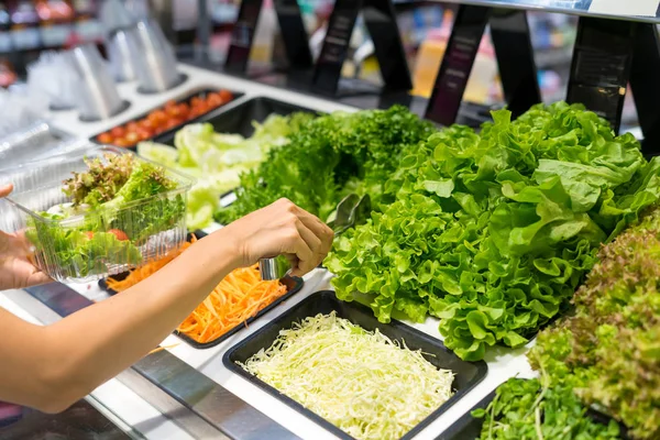 Mulheres comprando salada bar com legumes no supermercado — Fotografia de Stock