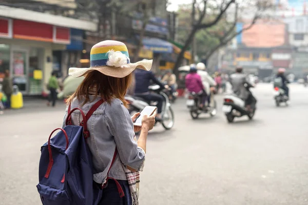 Jovem viajante usando um aplicativo em seu smartphone — Fotografia de Stock