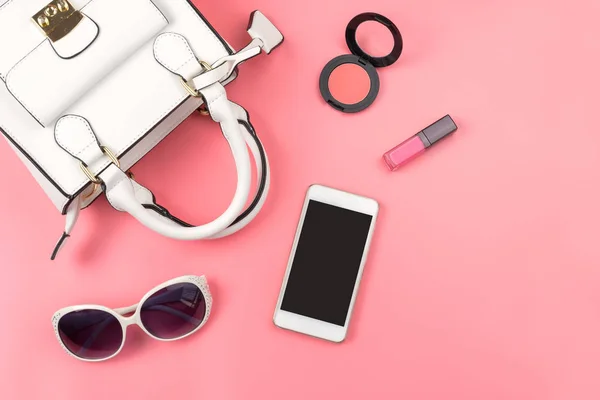 Bolso de mano para mujer con maquillaje y accesorios aislados en respaldo rosa — Foto de Stock