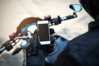 Motosiklet sürme ve akıllı telefon tutarak motorcu