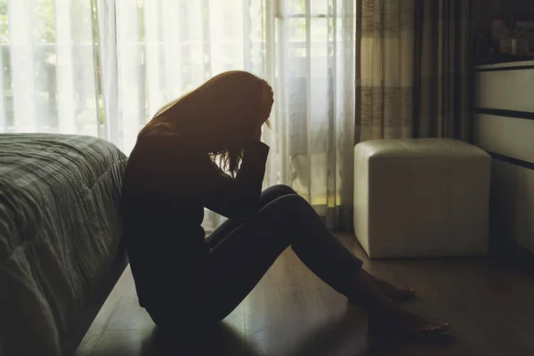 Depressive Frau sitzt im dunklen Schlafzimmer — Stockfoto