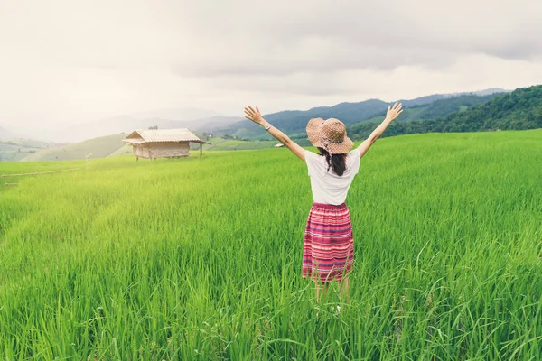 Mujer viajero mirando puesta de sol en el campo de terrazas de arroz verde — Foto de Stock