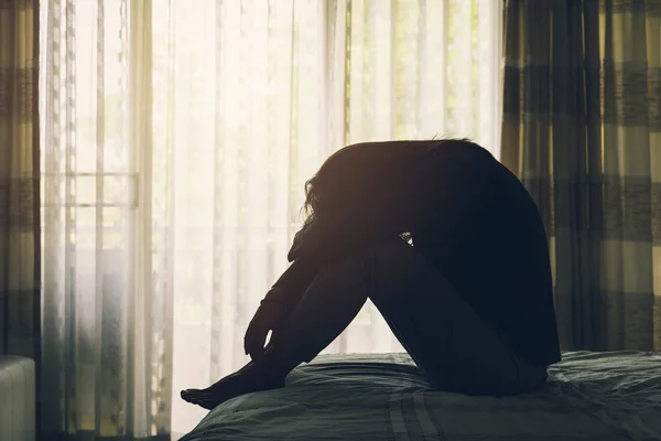 Kadın yatakta oturup depresyon acı