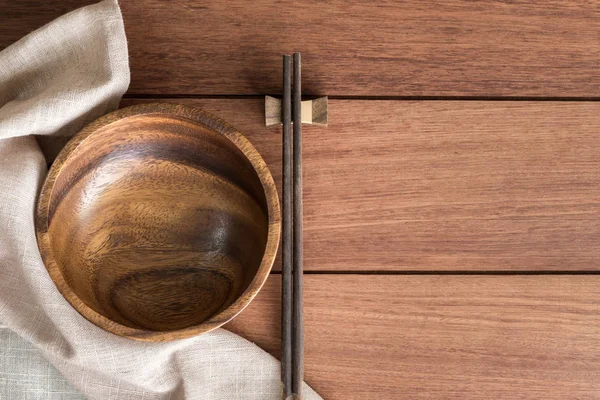 Wooden bowl with chopsticks on wooden table — Stock Photo, Image