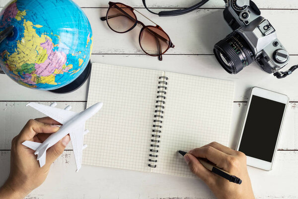 Traveler planning trip on notebook and smart phone, Travel concept