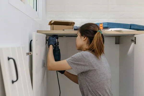 Jeune femme utilisant tournevis électrique pour l'installation — Photo