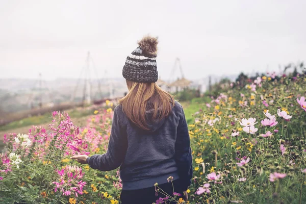 Junge Frau geht im Blumenfeld spazieren — Stockfoto