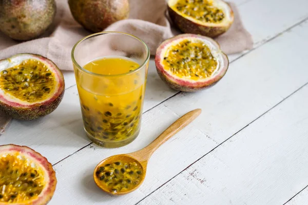 Passion fruit and juice on white wooden background — Stock Photo, Image