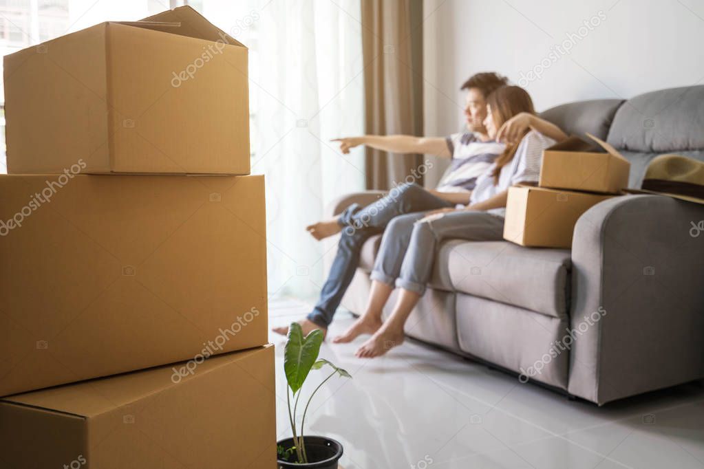 Young happy couple moving in new home, sitting and relaxing