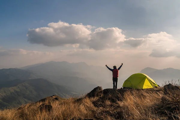 Young man traveler with backpack camping on mountain, Adventure
