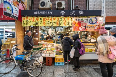 Osaka, Japonya - 7 Şubat 2020: Japonya 'nın Osaka kentindeki ünlü turizm merkezi Kuromon Ichiba balık pazarında yürüyen kalabalık