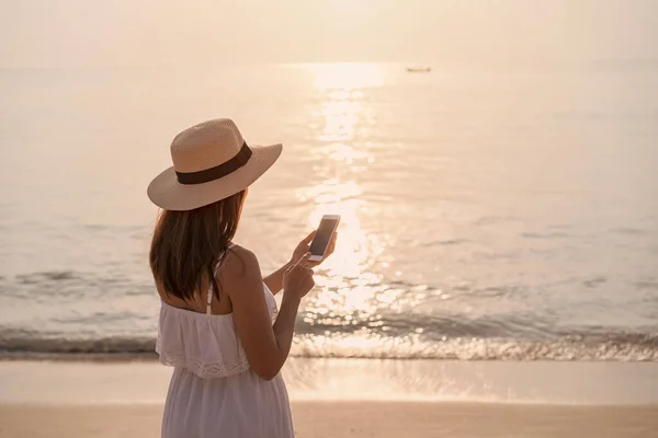 Νεαρή Γυναίκα Ταξιδιώτη Χρησιμοποιώντας Κινητό Τηλέφωνο Τροπική Παραλία Στο Ηλιοβασίλεμα — Φωτογραφία Αρχείου
