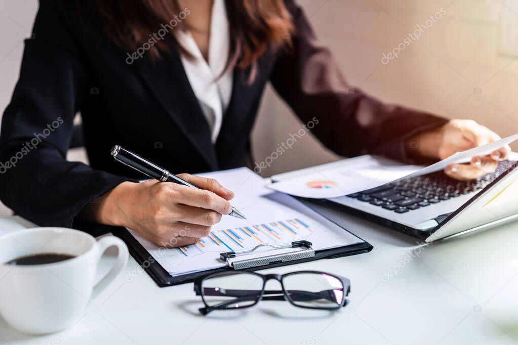 Businesswoman working on Desk office with computer and marketing graph statistics analysis
