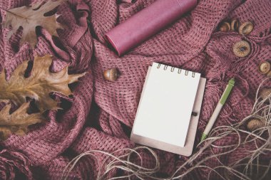 Örtünün üzerinde kurumuş yapraklar olan defter.