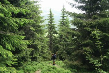 Sırt çantalı bir adam yolda yürüyor..