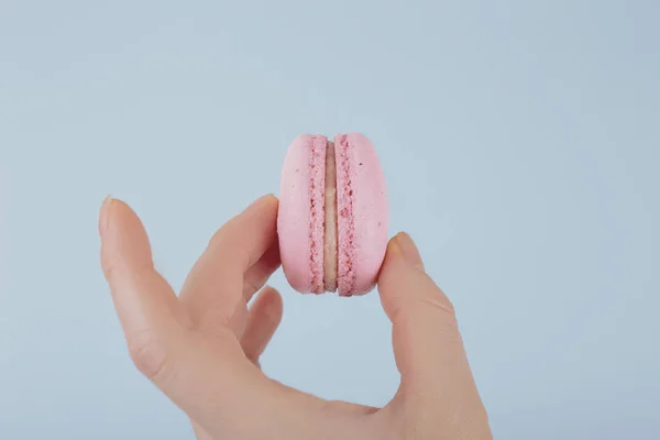 Macaroons rosa saborosos na mão feminina — Fotografia de Stock