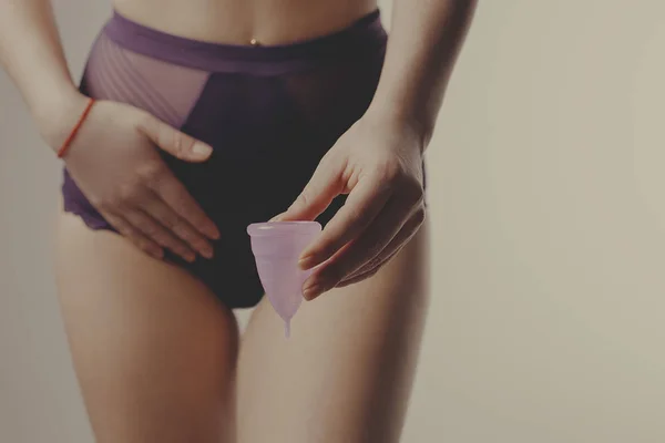 Mujer sosteniendo copa menstrual en frente de sus partes íntimas . — Foto de Stock