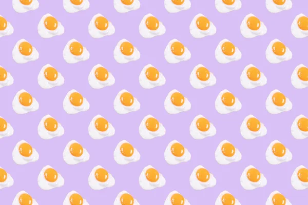 Fried eggs pattern on pink background. View from above. Food fashion minimalistic concept.
