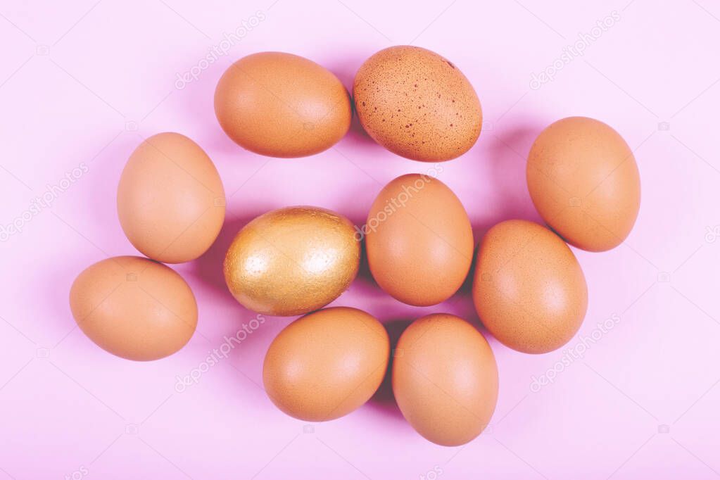 Close up of chicken eggs on plain pastel pink background with copy space