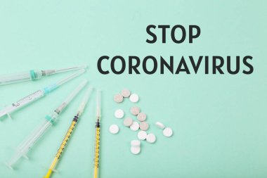Koronavirüsü durdurun. İlaç hapları ve renkli arka planda şırıngalar. Sağlık hizmeti, koronavirüs konsepti